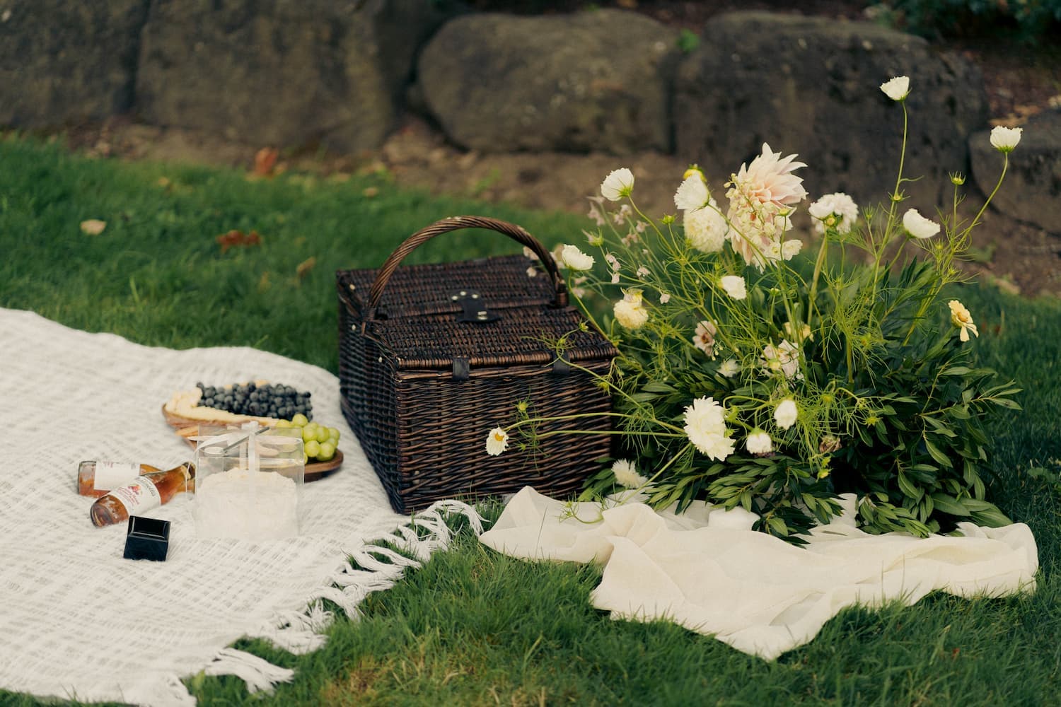 Picnic setup with flowers and the ring box